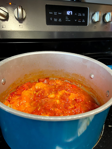 mixed tomatoes cooking to make homemade tomato sauce