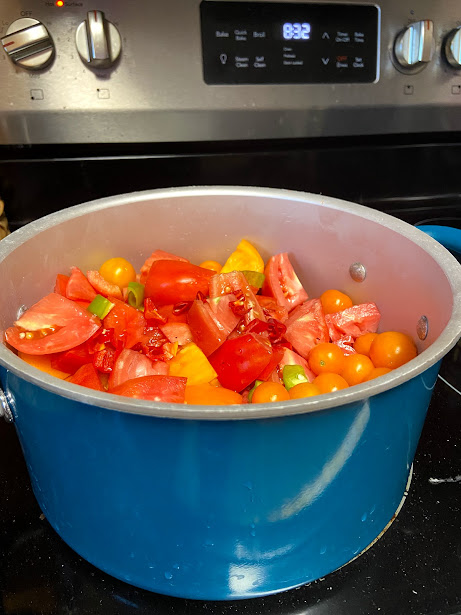 mixed tomatoes at start of cooking to make homemade tomato sauce
