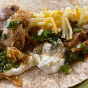 lamb shank taco with sour cream, jalapenos, and cheese