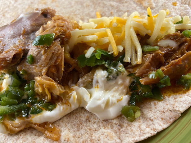 lamb shank taco with sour cream, jalapenos, and cheese