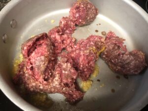 ground lamb cooking in skillet with spices