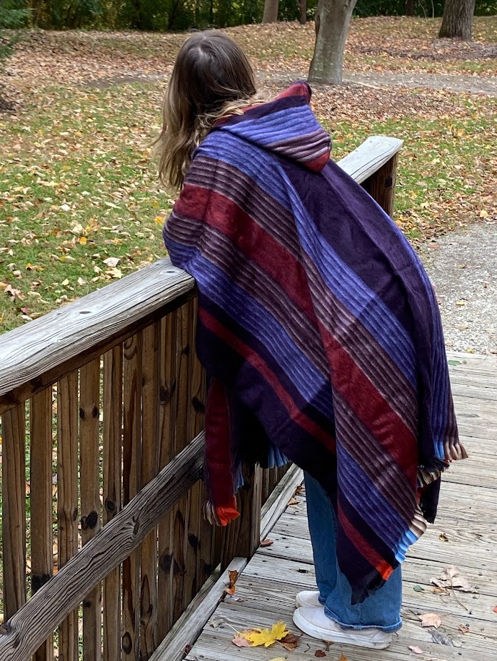 girl on bridge wearing multicolor alpaca poncho