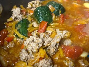 lamb chili with frozen kale cubes being aded